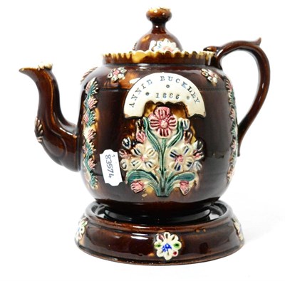 Lot 247 - A Measham bargeware teapot, cover and stand, inscribed ANNIE BUCKELEY 1886, 24cm high