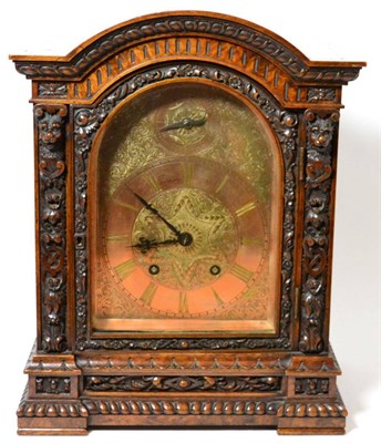 Lot 275 - A burr walnut carved quarter striking table clock, circa 1890, arched pediment, carved broders...