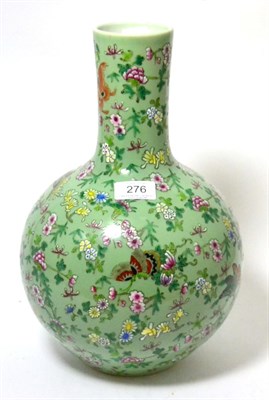 Lot 276 - A Cantonese style porcelain bottle vase, painted in famille rose enamels with butterflies and...