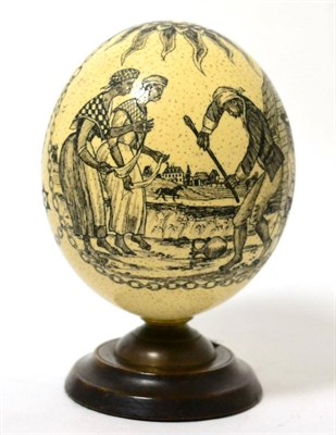 Lot 278 - A scrimshaw ostrich egg, decorated with an American eagle and a slavery scene, 14cm high, on a...