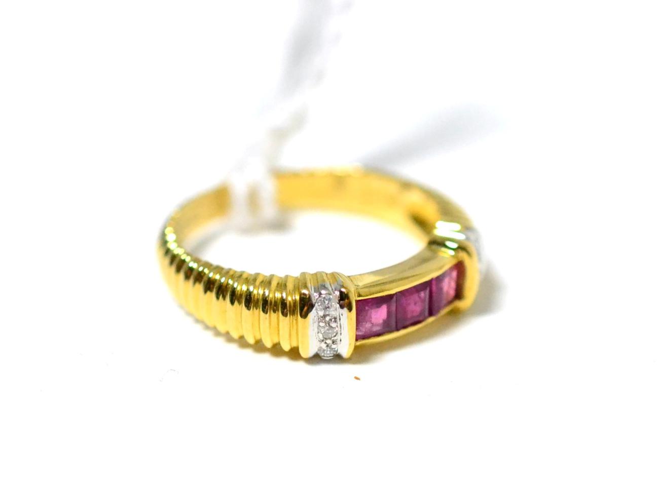 Lot 346 - A ruby and diamond ring, three square cut rubies in yellow channel settings to diamond set...