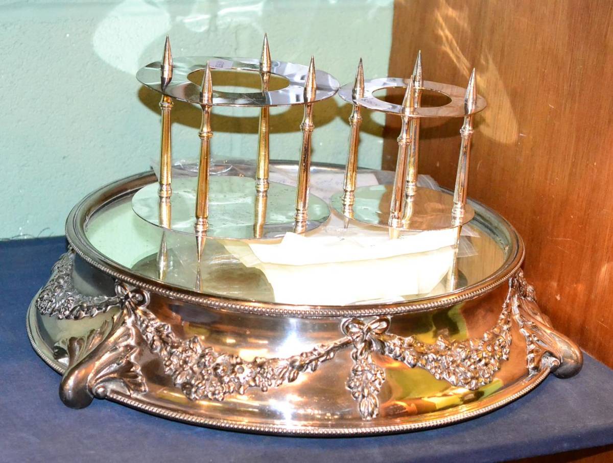 Lot 578 - A silver plated wedding cake stand with mirrored plateau within a swag and leaf cast base, 42cm...