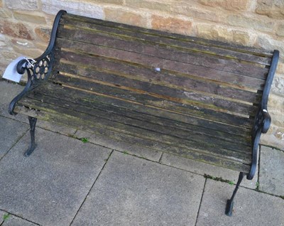 Lot 1150 - A matched pair of cast iron garden benches, with wooden slats, 149cm wide and 127cm wide