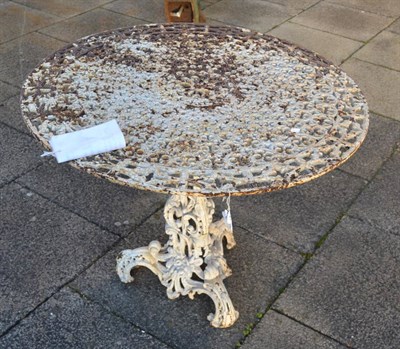 Lot 1154 - A painted and rusted foliated decorated cast iron circular garden table, with acanthus scrolled...