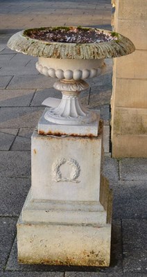 Lot 1160 - A pair of Victorian cast iron urns with gadrooned rims raised on square platform bases the...
