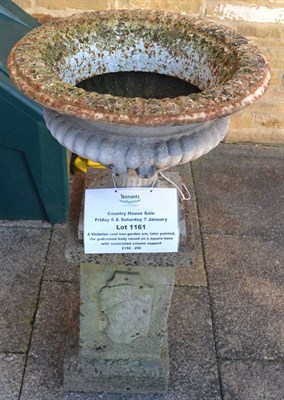 Lot 1161 - A Victorian cast iron garden urn, later painted, the gadrooned body raised on a square base...