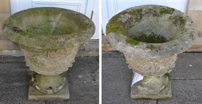 Lot 1163 - A pair of weathered composition garden urns of campana form, the bodies decorated with...