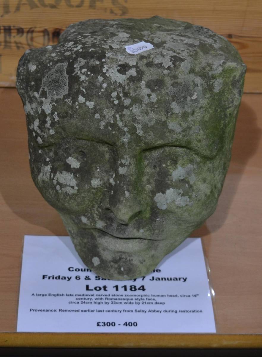 Lot 1184 - A large English late medieval carved stone zoomorphic human head, circa 16th century, with...