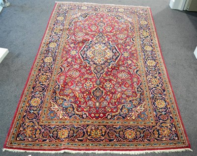 Lot 1200 - Kashan rug, Central Iran, the raspberry field of palmettes and vines around an indigo pole...