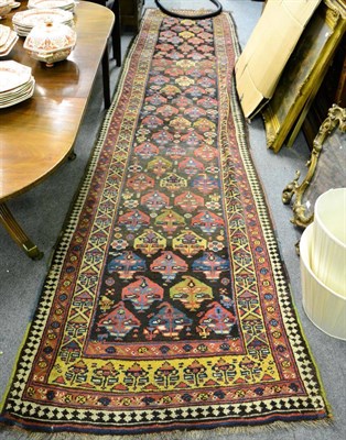 Lot 1211 - Kurdish runner, North West Iran, the field with a lattice of polychrome stylised boteh enclosed...