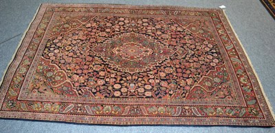 Lot 1216 - Saroukh rug, West Iran, the deep indigo field of plants around a cusped anchor medallion framed...