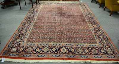 Lot 1219 - Saroukh carpet, West Iran, the brick red field with an allover Herati design enclosed by indigo...