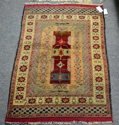 Lot 1224 - Mauri Afghan silk rug, the field with twin burgundy panels enclosed by ivory borders, 108cm by 76cm