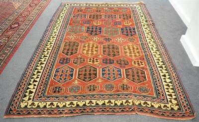 Lot 1227 - A Kazak rug, Central Caucasus, the madder field with columns of polychrome octagons...