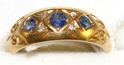 Lot 6 - An 18 carat gold sapphire and diamond ring, three graduated round cut sapphires spaced by eight-cut