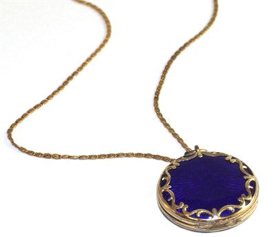 Lot 9 - A blue guilloche enamel locket, a circlar locket with applied scroll decoration, hinged to open and