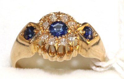 Lot 12 - An 18 carat gold sapphire and diamond ring, a round cut sapphire within a border of eight-cut...
