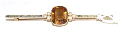 Lot 13 - A citrine and split pearl bar brooch, an oval cut citrine in a yellow milgrain setting between...