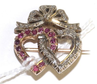 Lot 27 - A ruby and diamond twin heart brooch, one heart set with round cut rubies in yellow claw...