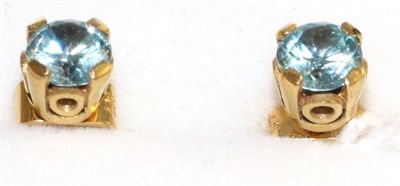 Lot 28 - A pair of aquamarine stud earrings, a round cut aquamarine in a yellow claw setting and above a...