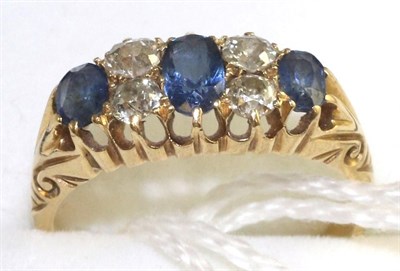 Lot 30 - An 18 carat gold sapphire and diamond ring, three graduated oval cut sapphires spaced by two...