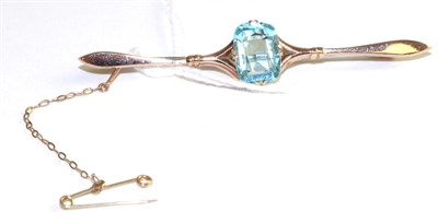 Lot 31 - An aquamarine bar brooch, a cushion cut aquamarine in a yellow double claw setting, to a forked...