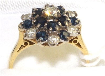 Lot 32 - An 18 carat gold sapphire and diamond cluster ring, set throughout with round brilliant cut...