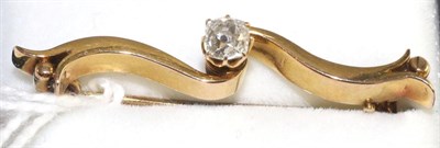 Lot 37 - A diamond bar brooch, an old cut diamond in a yellow claw settings to a scroll bar, estimated...