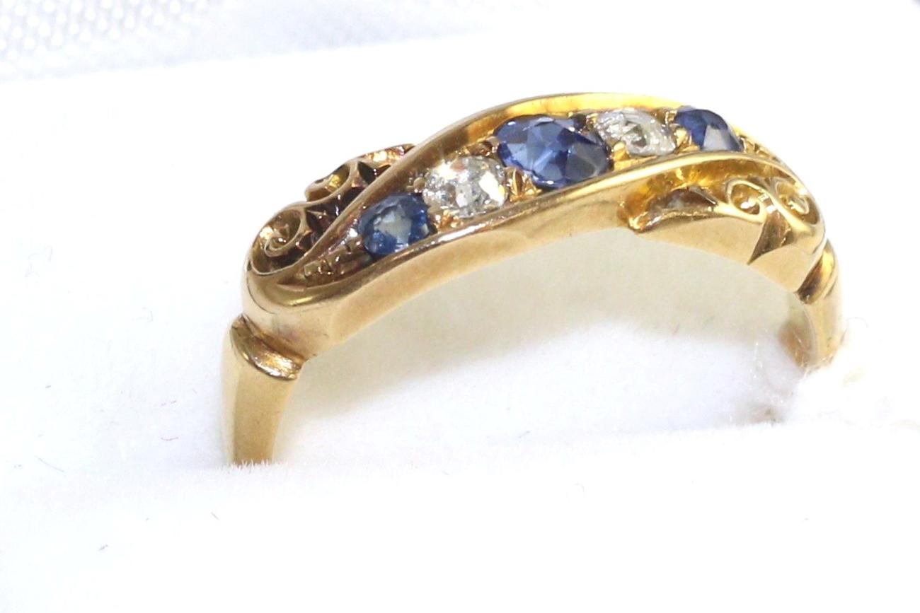 Lot 39 - An 18 carat gold sapphire and diamond ring, three graduated round cut sapphires, spaced by two...