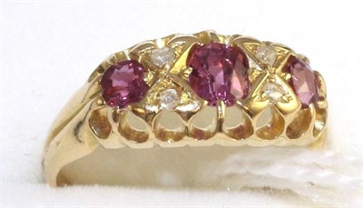 Lot 43 - An 18 carat gold ruby and diamond ring, three graduated oval cut rubies spaced by rose cut...