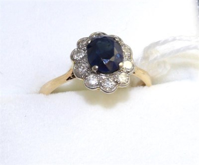 Lot 53 - A sapphire and diamond cluster ring, an oval cut sapphire within a border of round brilliant...