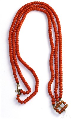 Lot 74 - A coral necklace, three strands of off round coral beads knotted to a coral set clasp, 40cm long