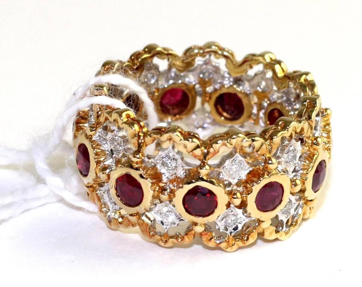 Lot 76 - A ruby and diamond eternity ring, round cut rubies in yellow rubbed over settings, spaced by...