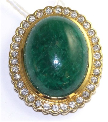 Lot 80 - An emerald and diamond brooch/pendant, circa 1960, an oval emerald cabochon in a yellow bezel...