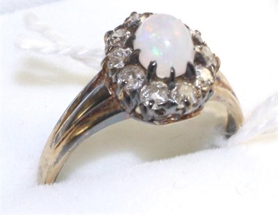 Lot 89 - An opal and diamond cluster ring, an oval cabochon opal within a border of old cut diamonds in...