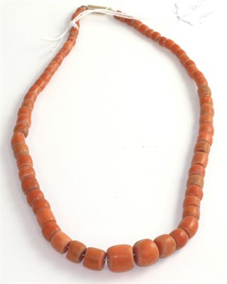Lot 100 - A coral necklace, barrel shaped coral beads to a yellow barrel clasp, length 50cm, gross weight...