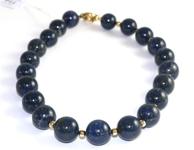 Lot 114 - A lapis lazuli bead necklace, large beads alternate with small yellow beads, length 56cm