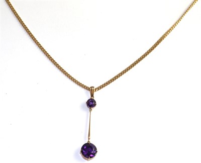 Lot 117 - An amethyst necklace, a round cut amethyst suspends a larger round cut amethyst by a yellow...