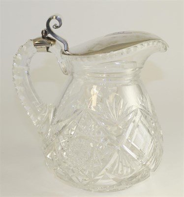 Lot 143 - A white metal mounted cut glass lemonade jug, early 20th century, of pear shape with scroll...