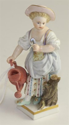Lot 230 - A Meissen porcelain figure of a girl, late 19th century, standing holding a watering can and sickle