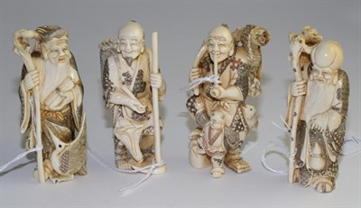 Lot 303 - A set of four Japanese carved ivory figures of Immortals, early 20th century, each holding a staff