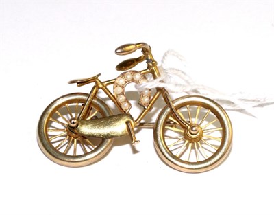 Lot 308 - A novelty bicycle brooch, with moving wheels and applied horseshoe, set with seed pearls,...