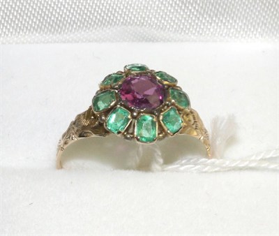 Lot 311 - A Victorian 12 carat gold rhodolite garnet and green paste ring, a round cut garnet within a border