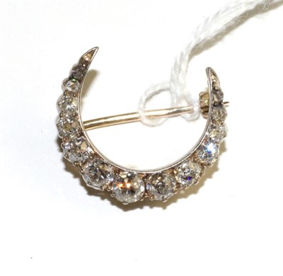 Lot 316 - A diamond crescent brooch, set throughout with old cut and rose cut diamonds in collet and claw...