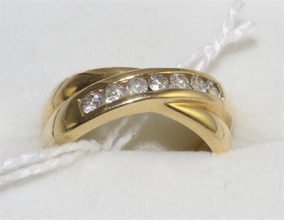 Lot 320 - An 18 carat gold diamond half hoop crossover ring, channel set with round brilliant cut...