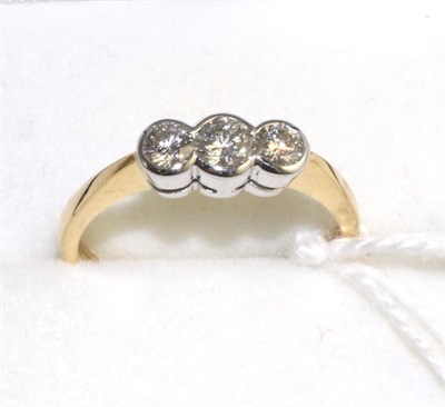 Lot 322 - An 18 carat gold diamond three stone ring, graduated round brilliant cut diamonds in white...