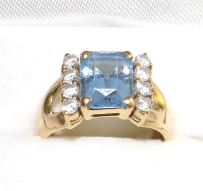 Lot 325 - A blue topaz and diamond ring, an emerald-cut blue topaz in a yellow four claw setting and...