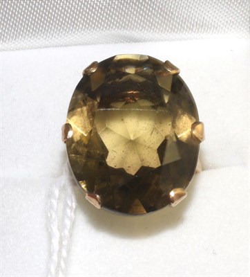 Lot 333 - A smokey quartz ring, an oval cut smokey quartz in a yellow claw setting with pierced...