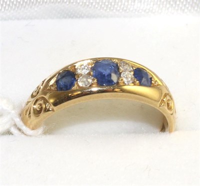 Lot 335 - An 18 carat gold sapphire and diamond cluster ring, three oval cut sapphires spaced by old cut...