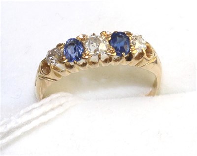 Lot 338 - An 18 carat gold sapphire and diamond ring, three old cut diamonds spaced by two oval cut sapphires